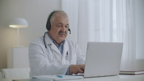 head-physician-of-physician-is-talking-with-employees-by-online-chat-on-laptop-during-daily-morning-meeting
